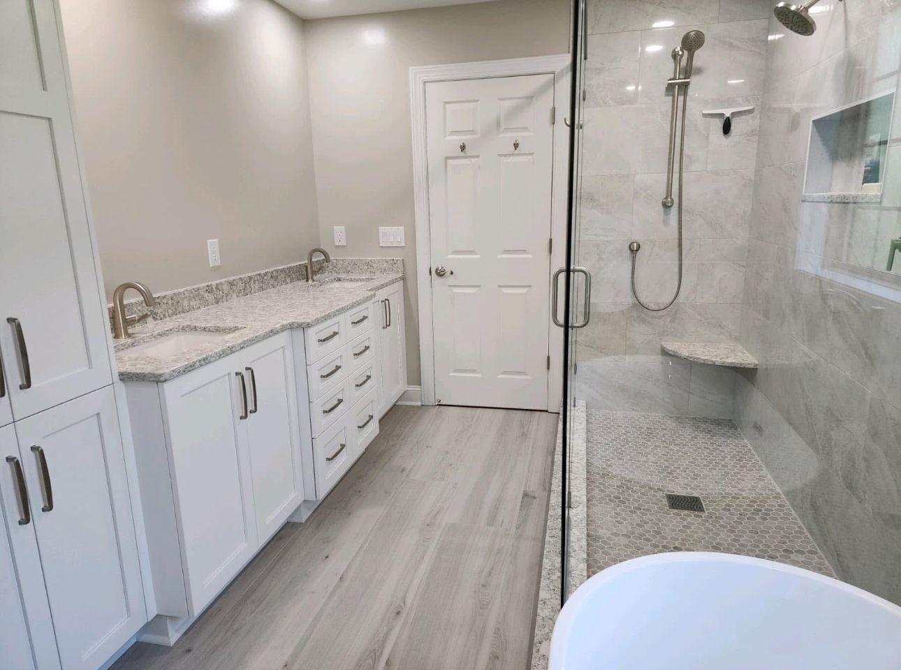 A bathroom with two sinks and a walk in shower.