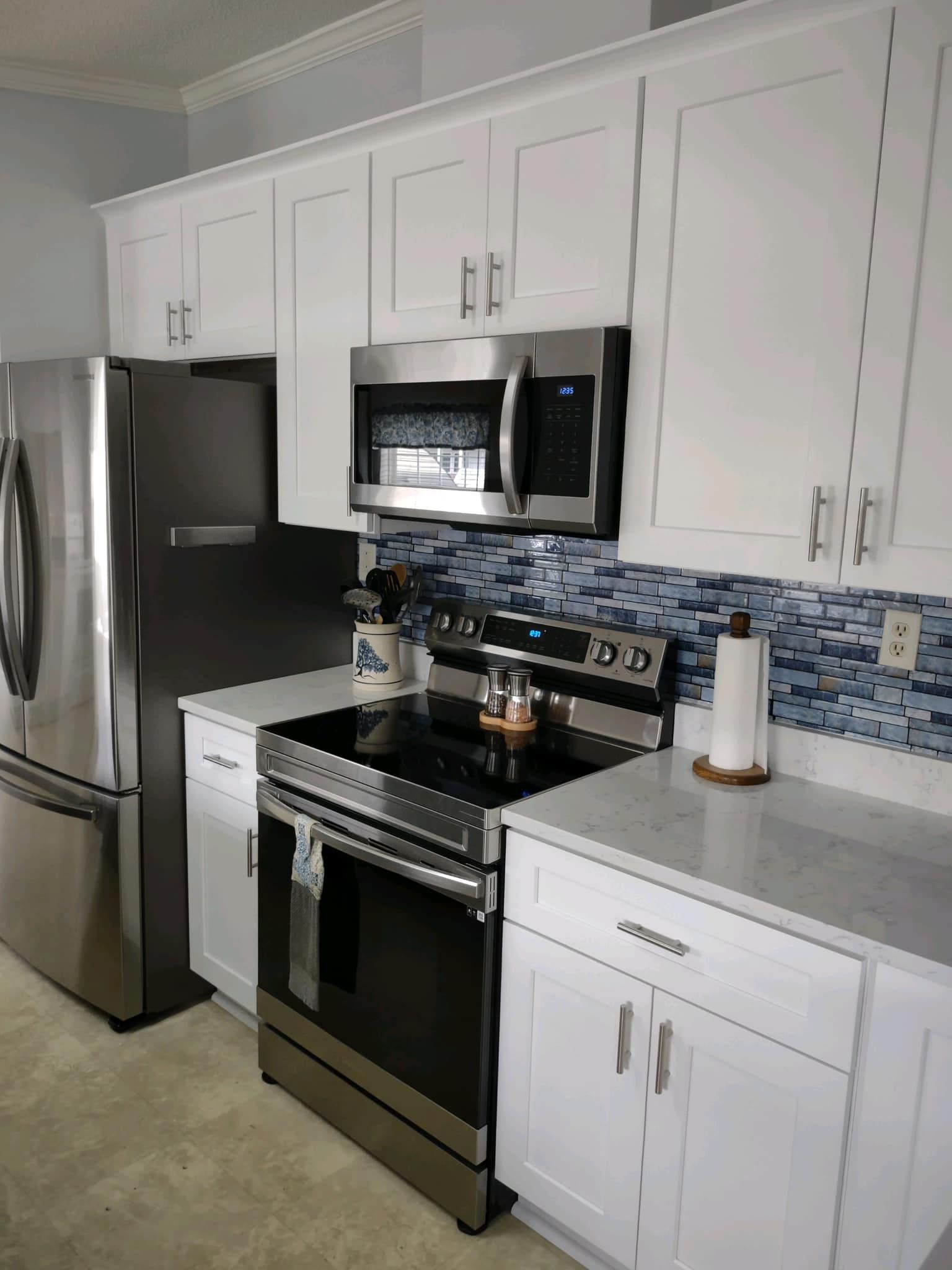 A kitchen with white cabinets and stainless steel appliances