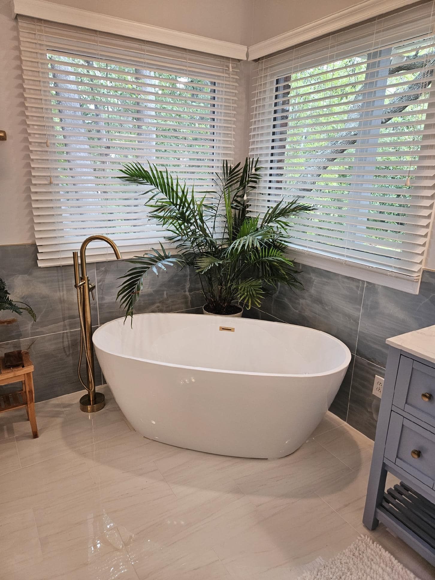 There is a bathtub in the middle of the bathroom next to a window.