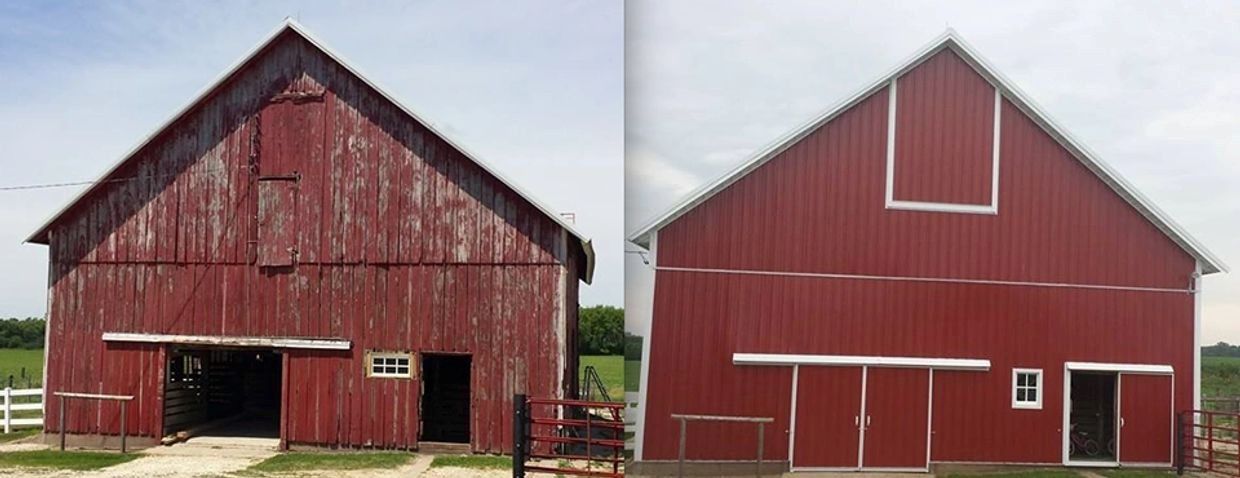 Two red barns side by side, one weathered and one freshly painted, with white trim.