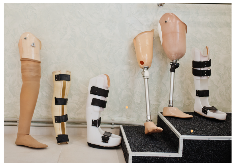Several prosthetic legs of varying designs displayed on a neutral background.
