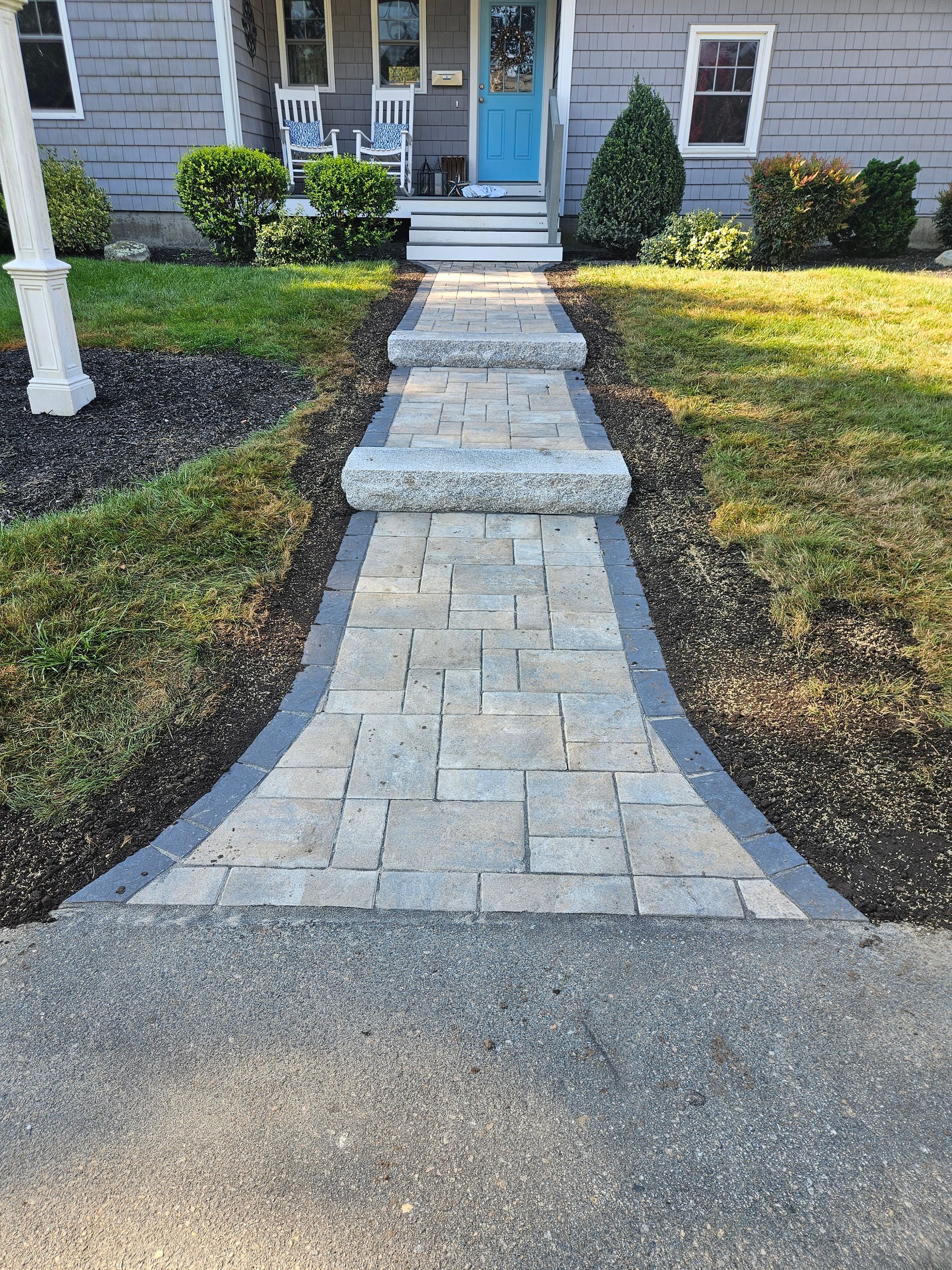 A stone walkway leading to the front door of a house.