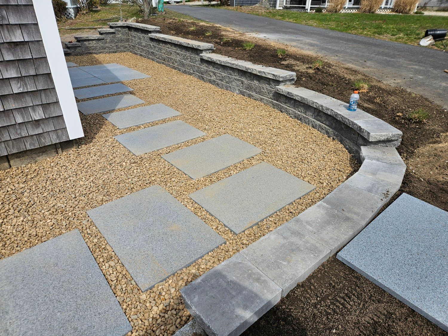 A stone walkway is being built in front of a house.