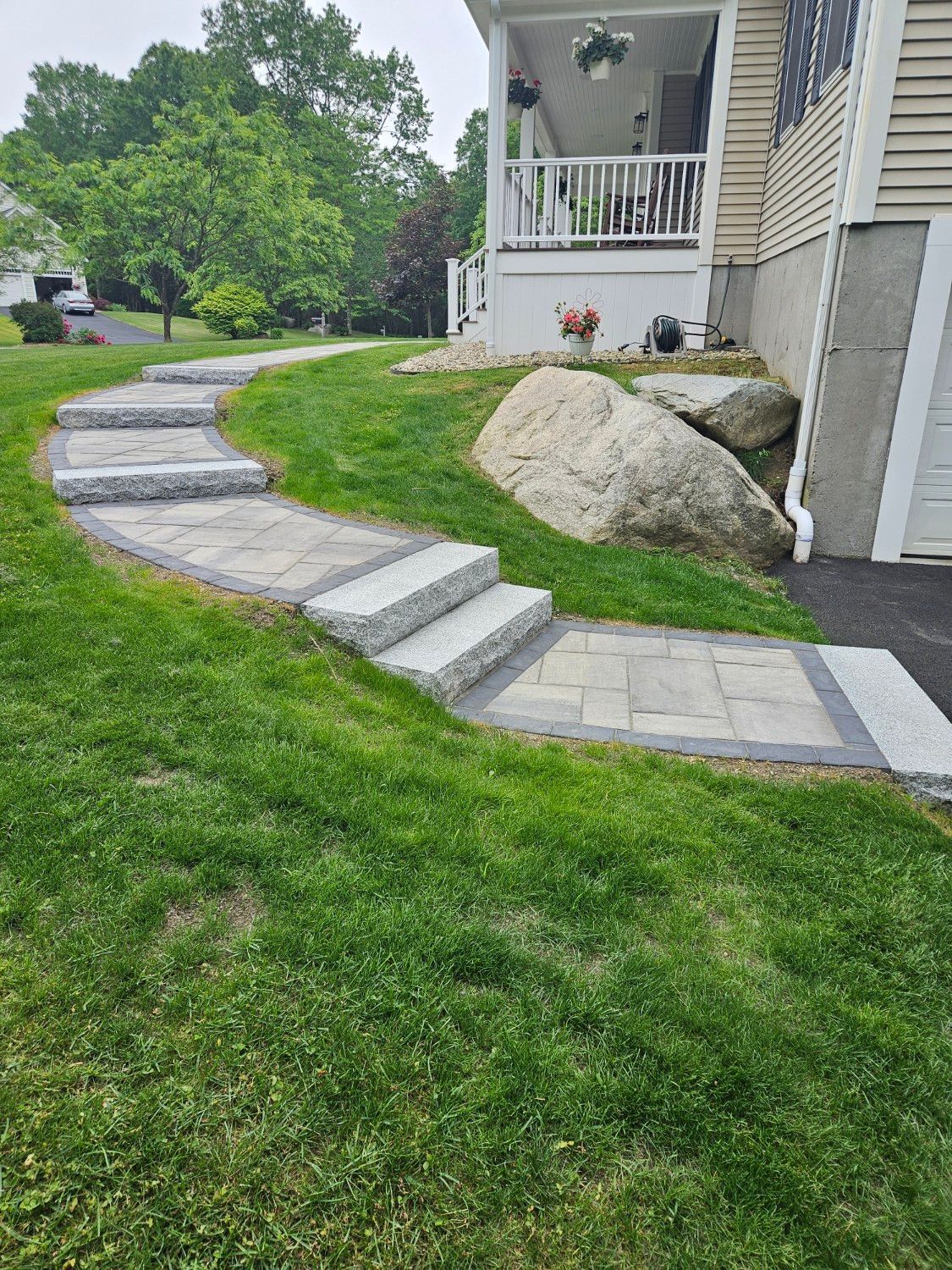 A stone walkway leading to a house with steps leading up to it.