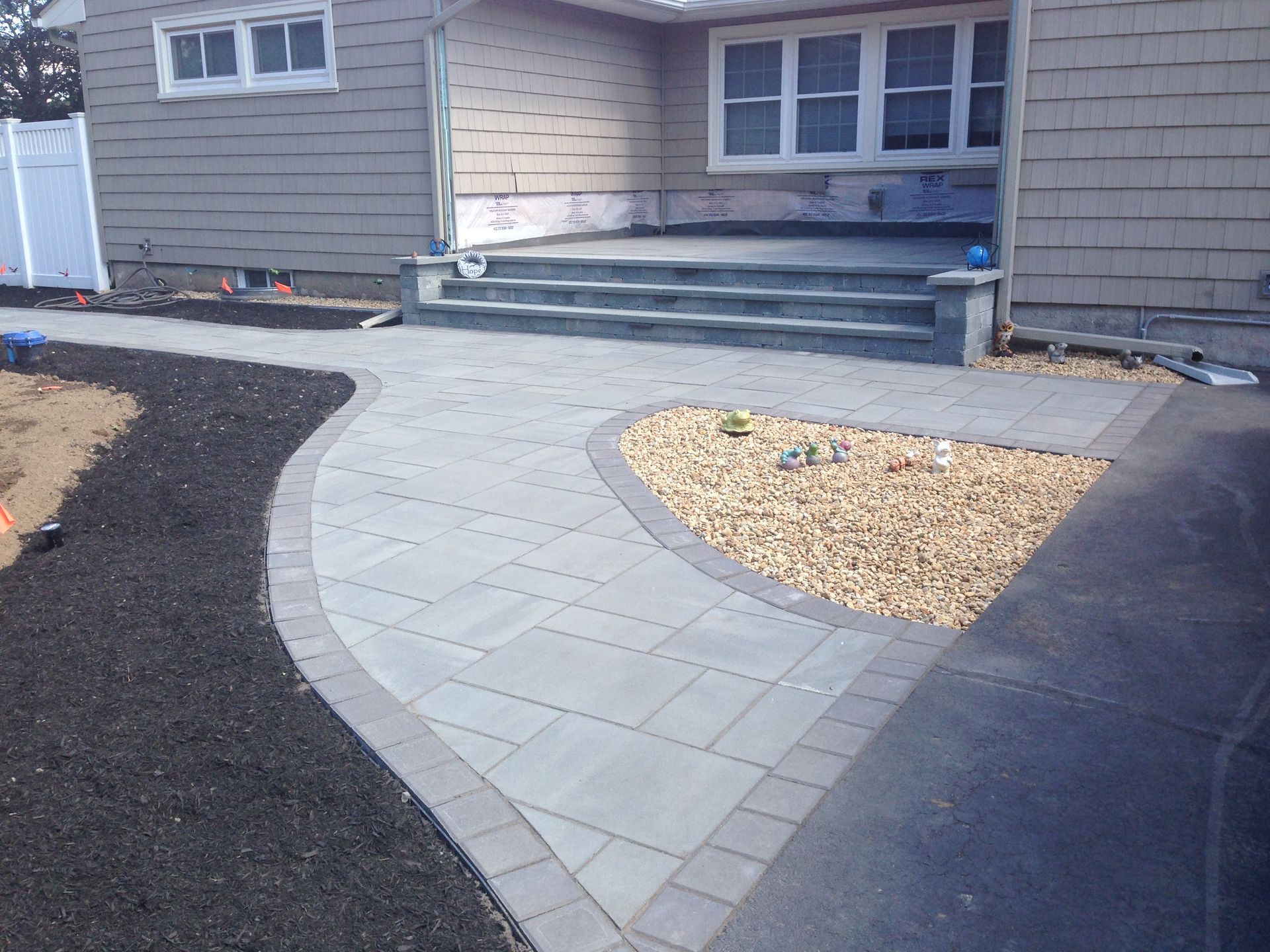 A brick walkway leading to the front of a house