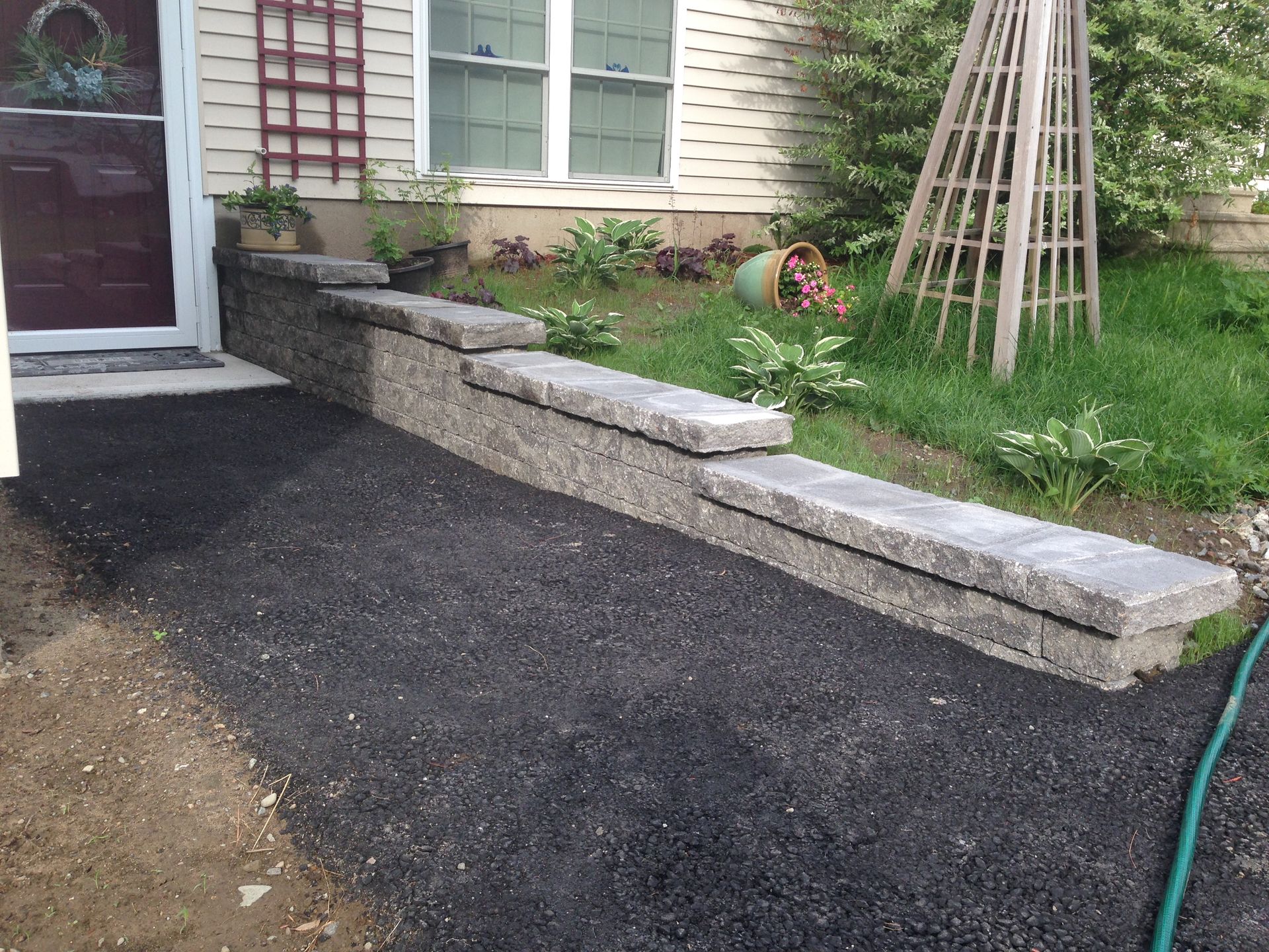 A hose is laying on the ground in front of a house