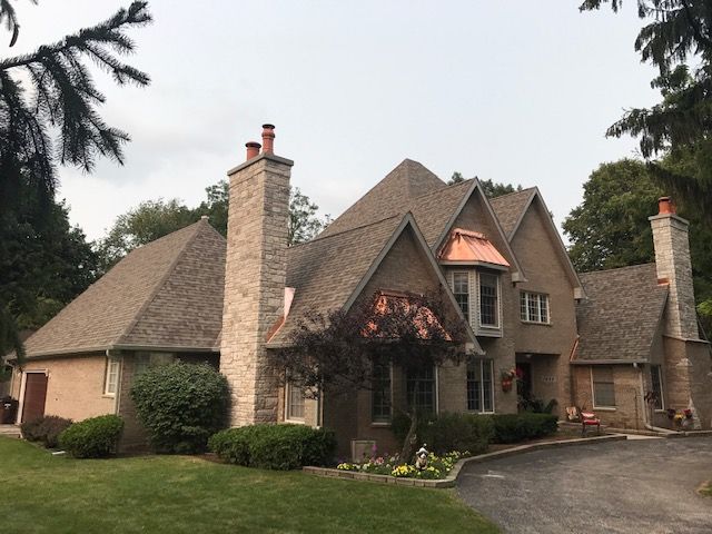 A large house with a copper roof and chimneys