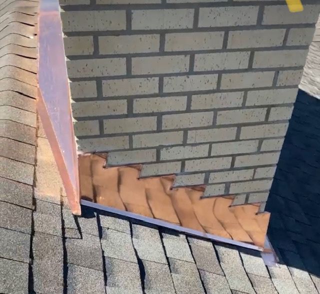 A close up of a brick wall and a roof