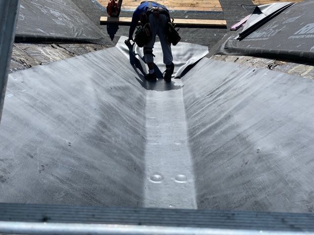 A man is working on the roof of a building
