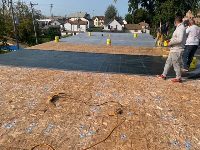 A group of men are working on a roof.