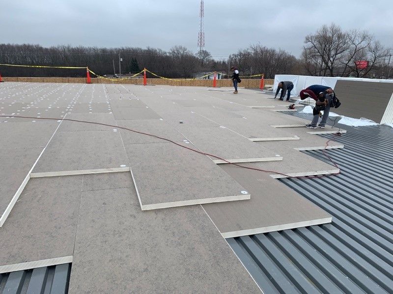 A group of construction workers are working on a roof.