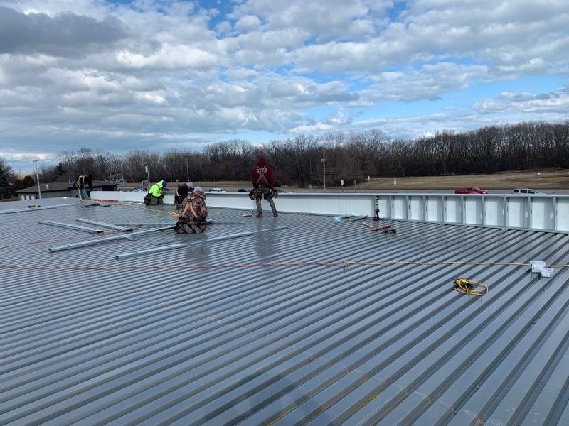A group of people are working on the roof of a building.