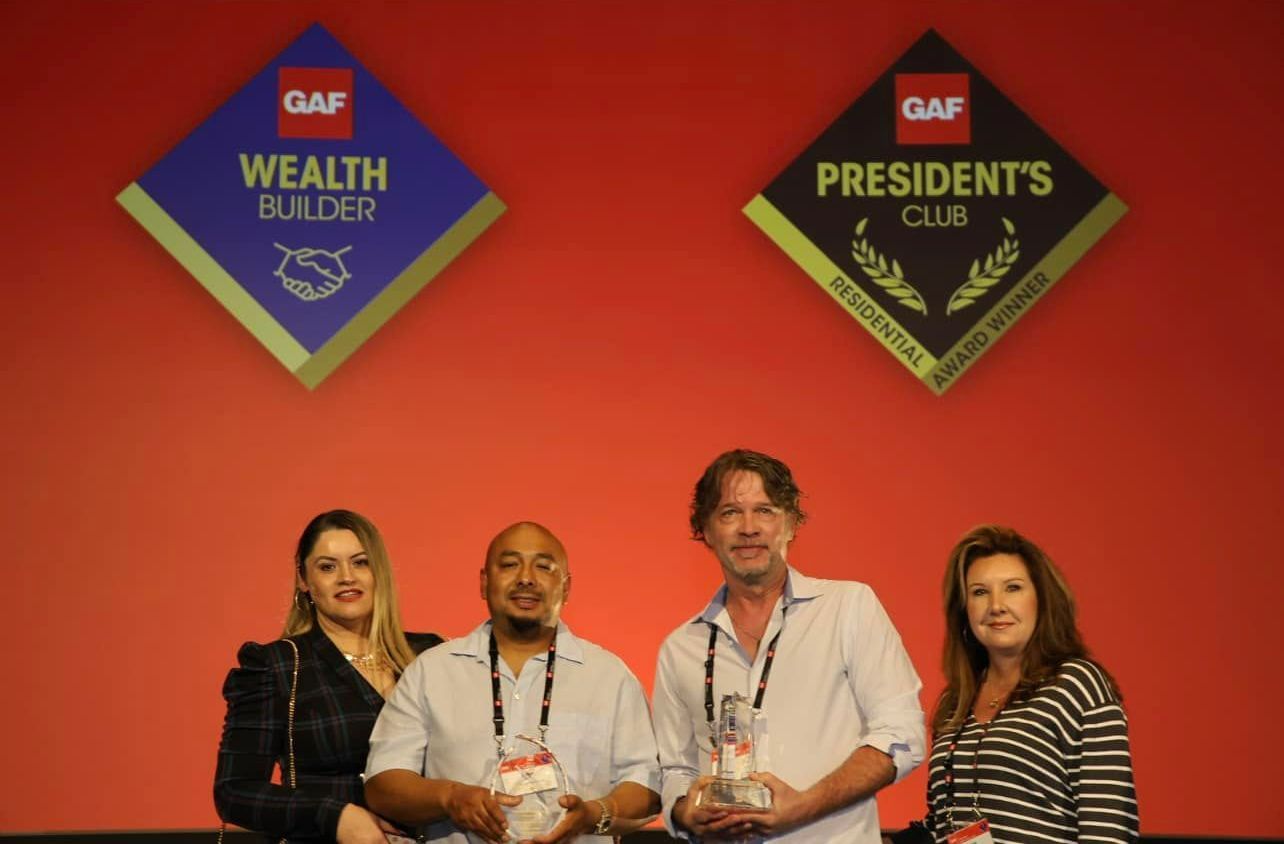 A group of people standing in front of a sign that says wealth builder