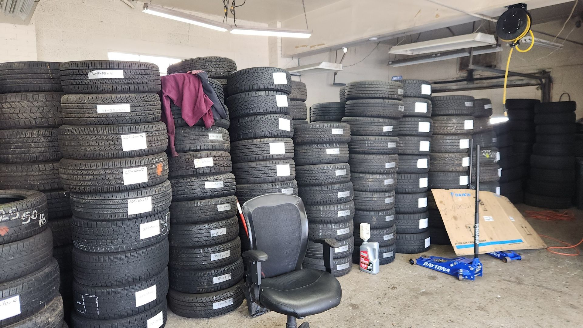 A warehouse filled with lots of tires stacked on top of each other.