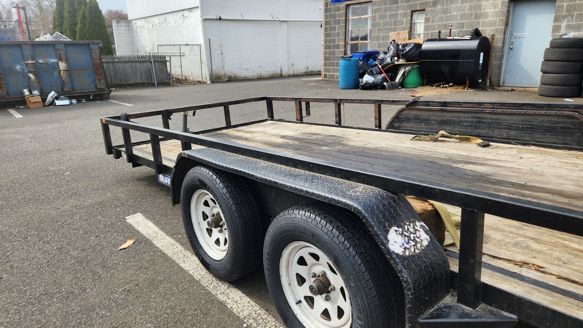 A trailer is parked in a parking lot in front of a building.