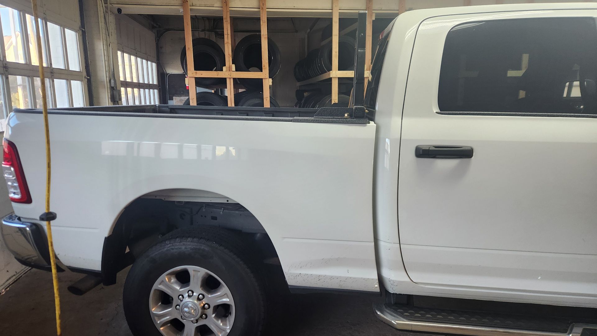 A white dodge ram truck is parked in a garage.