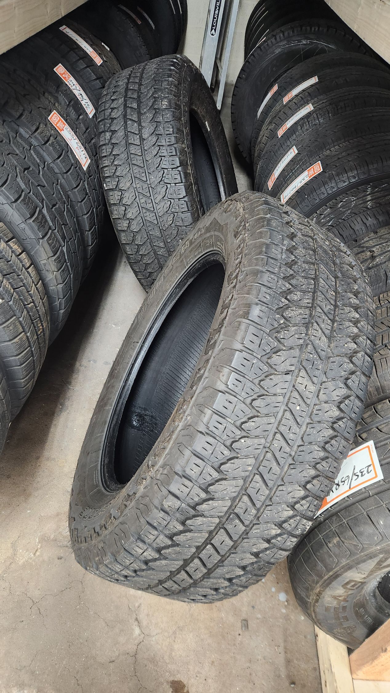 A bunch of tires are stacked on top of each other on the ground.