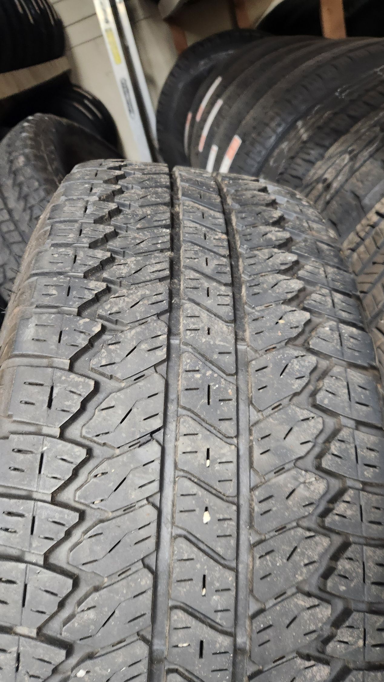 A close up of a tire sitting on top of a pile of tires.
