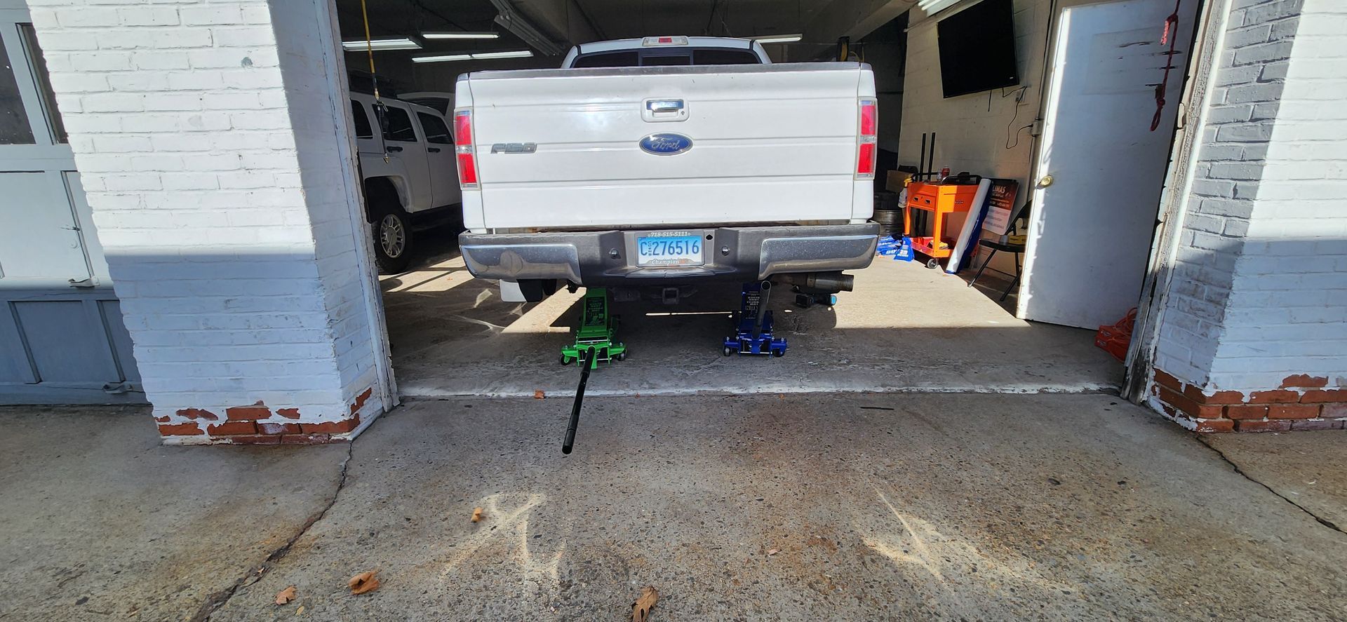 A white ford truck is parked in a garage.