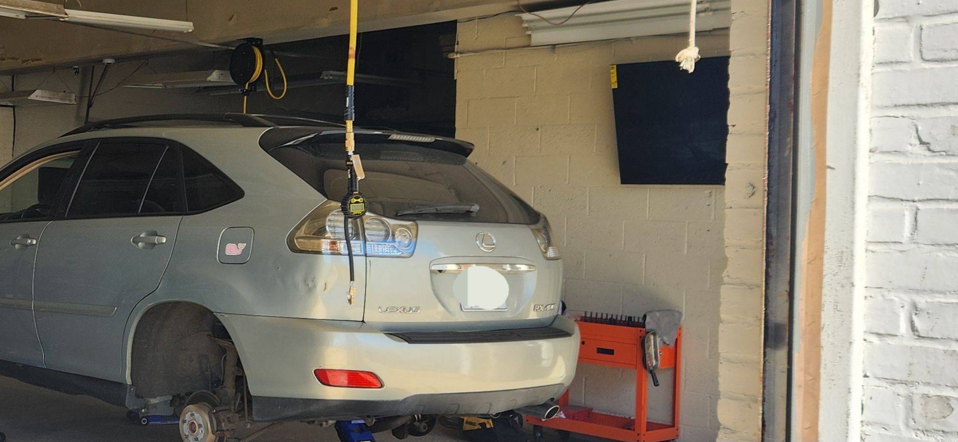 A car is sitting on a lift in a garage.