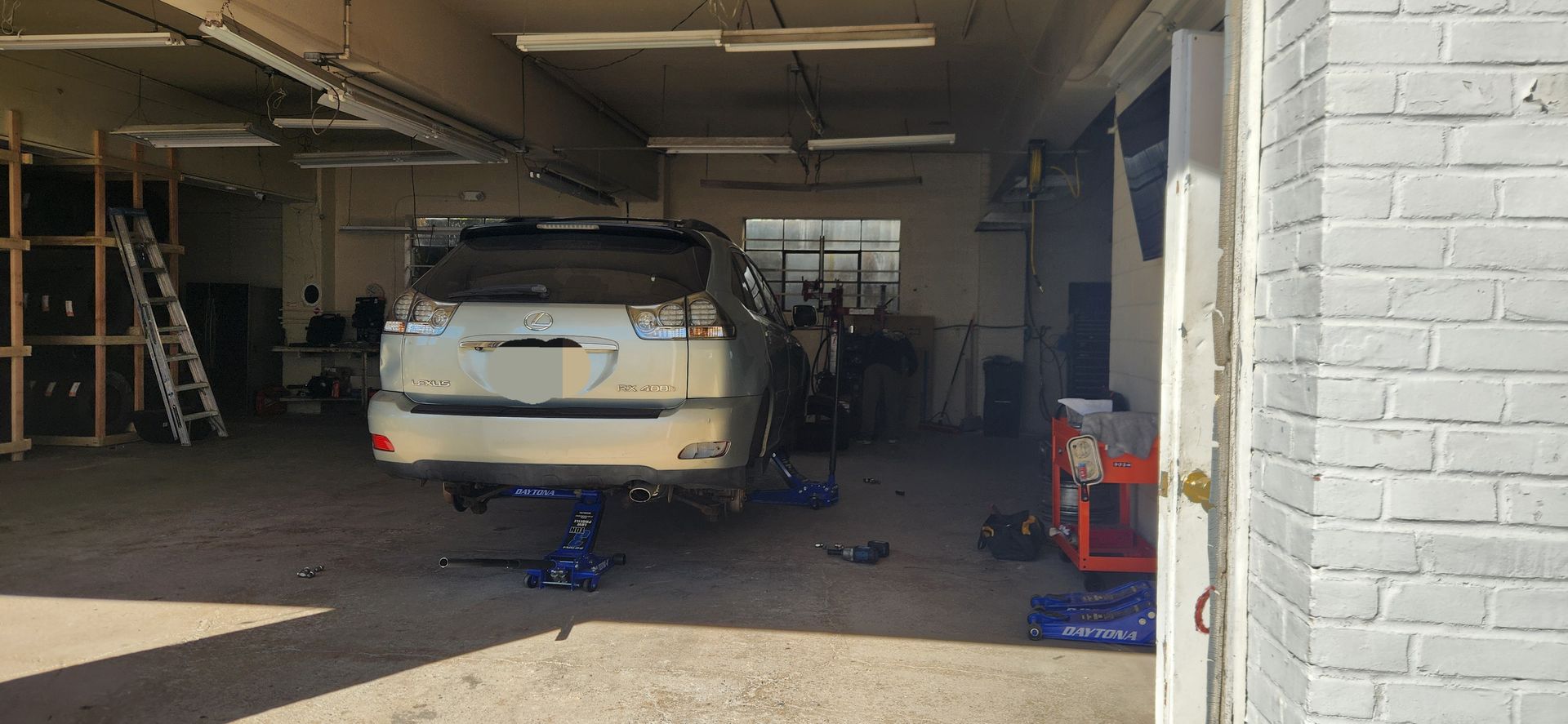 A car is sitting on a lift in a garage.