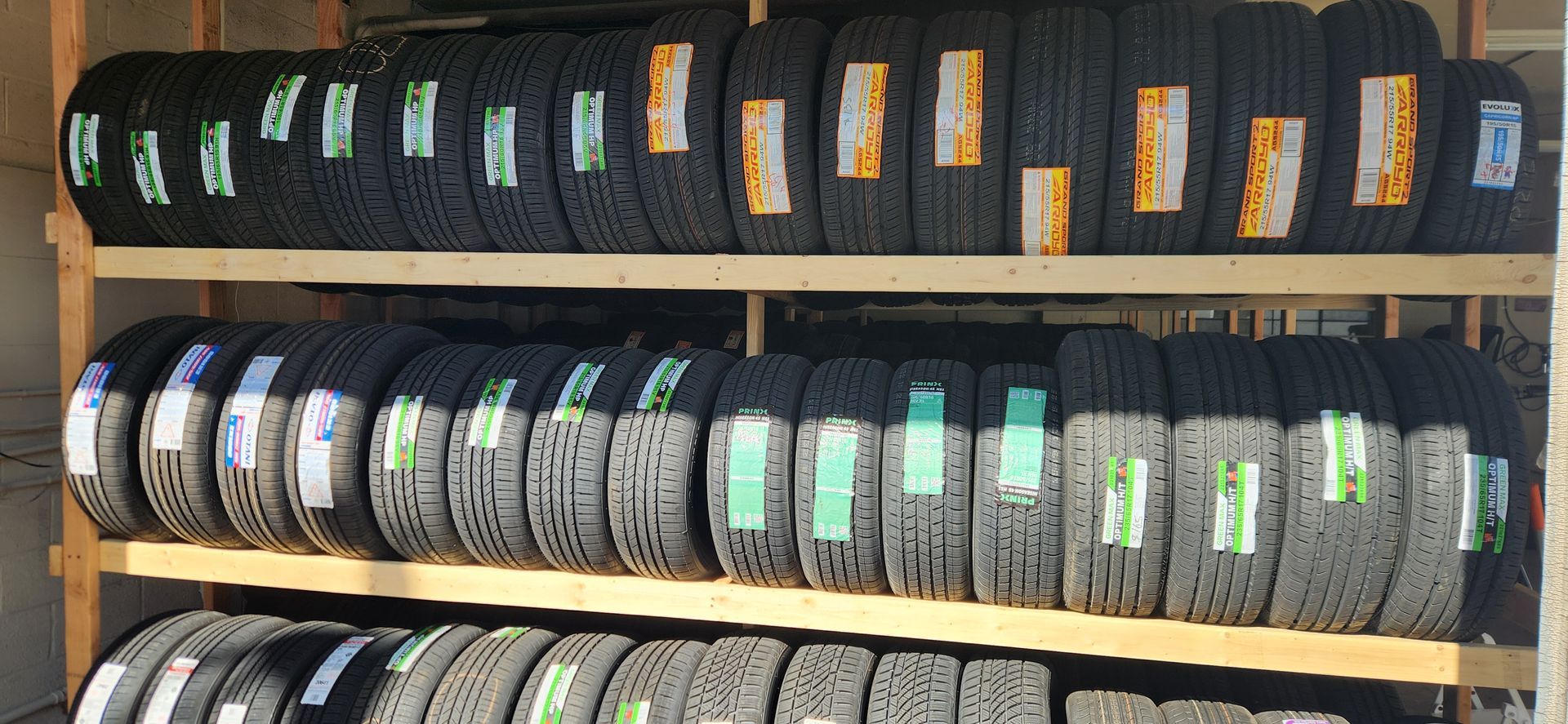 A shelf filled with lots of tires with labels on them.
