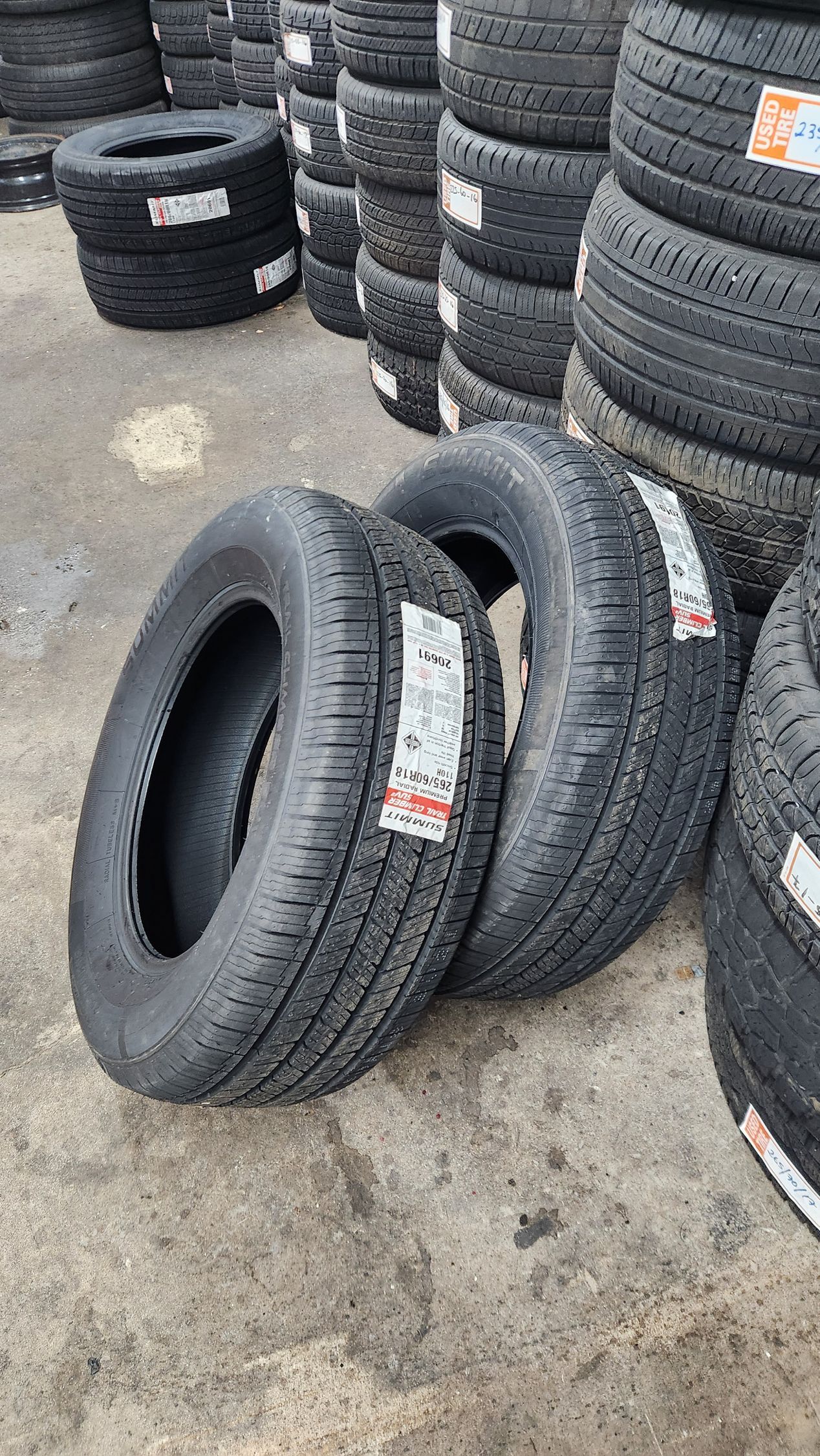 A bunch of tires are stacked on top of each other on the ground.