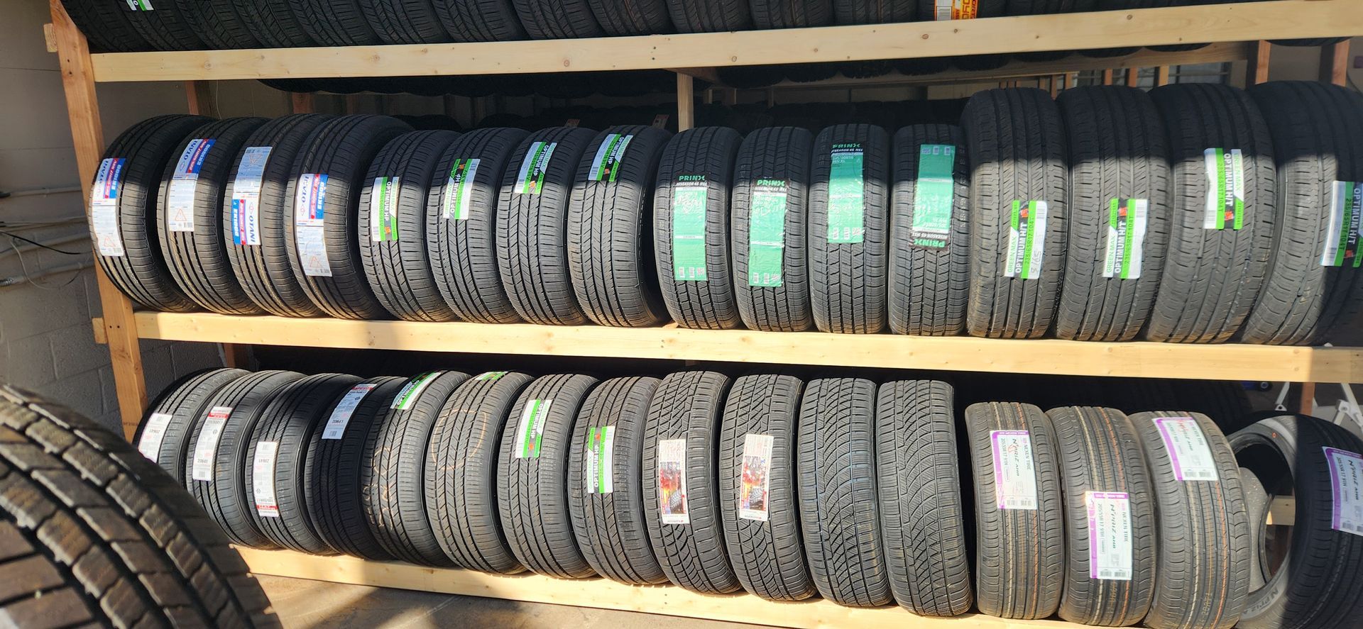 A bunch of tires are stacked on top of each other on a shelf.