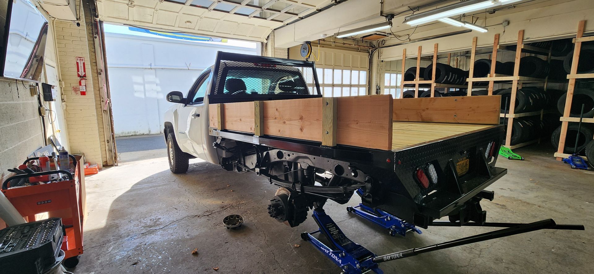 A truck is sitting on a jack in a garage.
