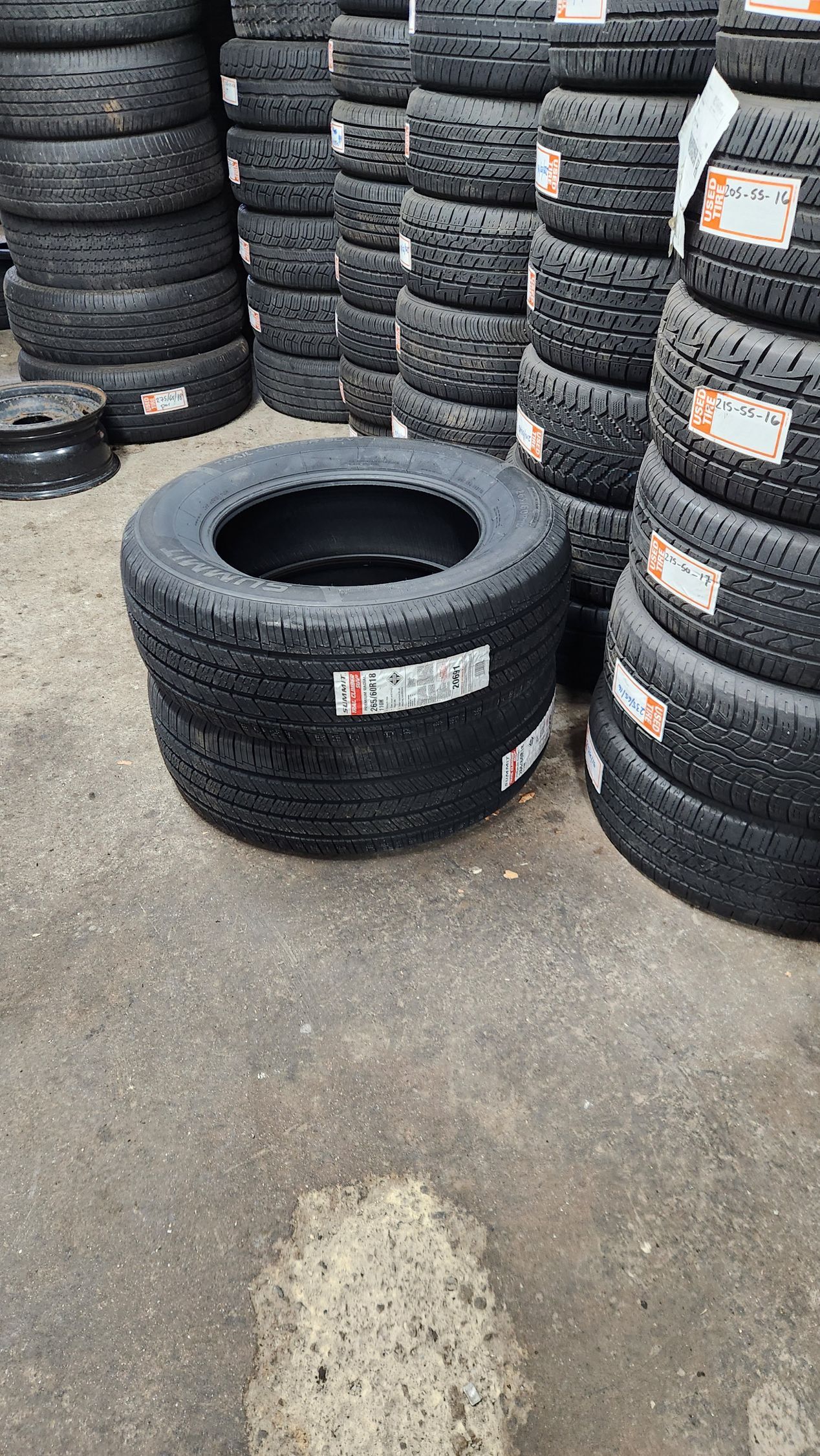 A pile of tires are stacked on top of each other on the ground.