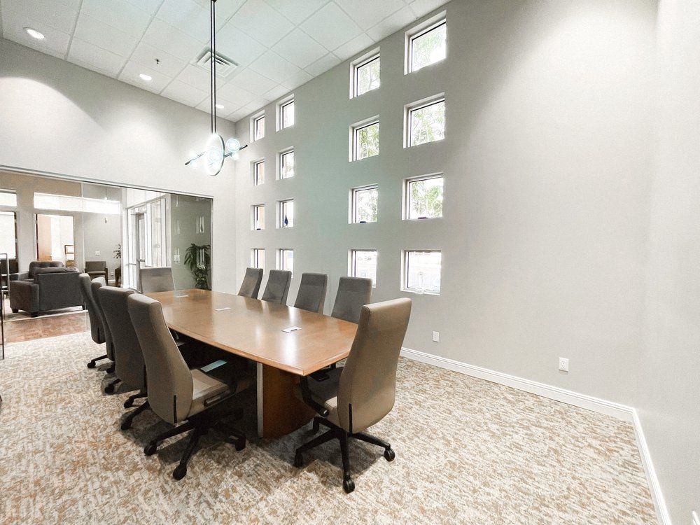 A conference room with a long table and chairs.