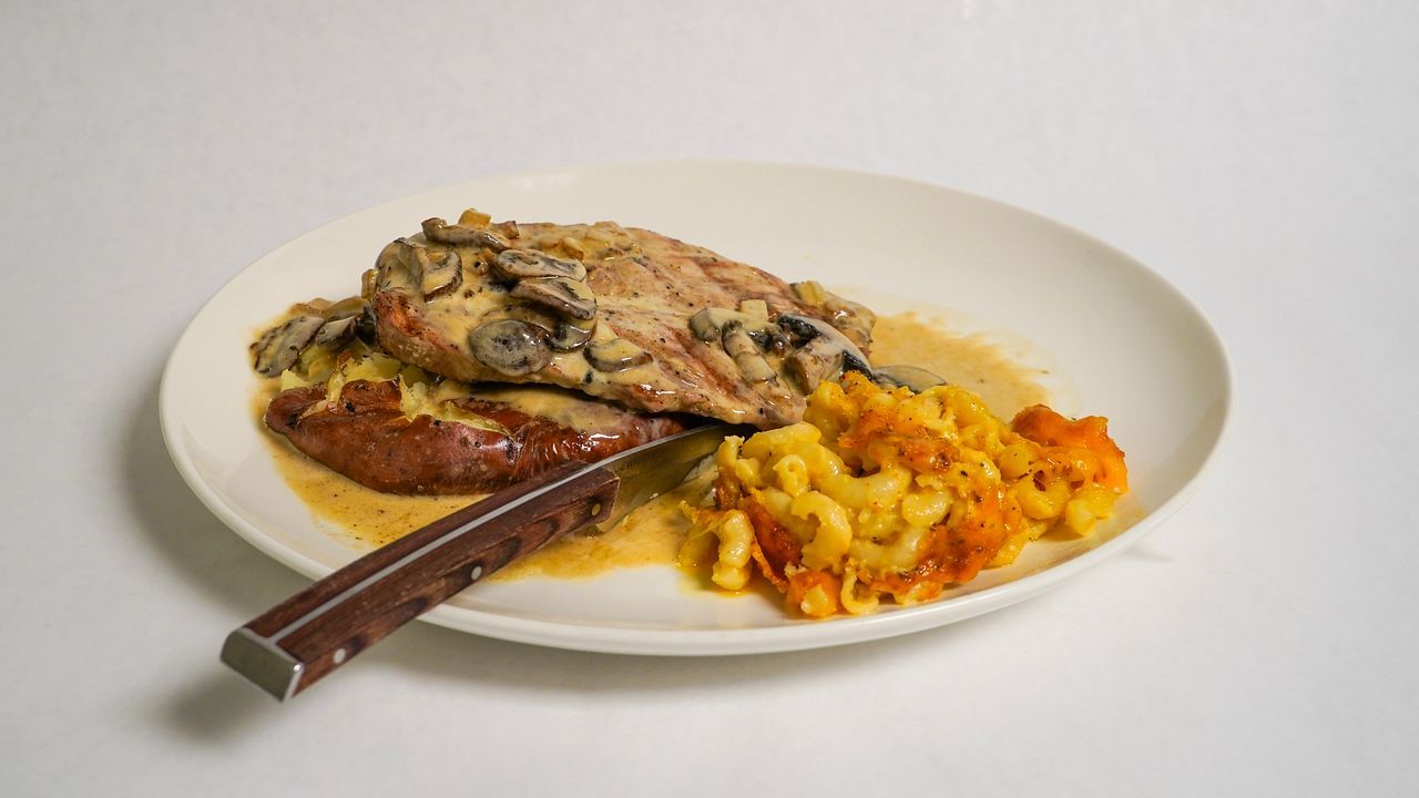 Plate of food: chicken with mushroom sauce, sausage, and squash.