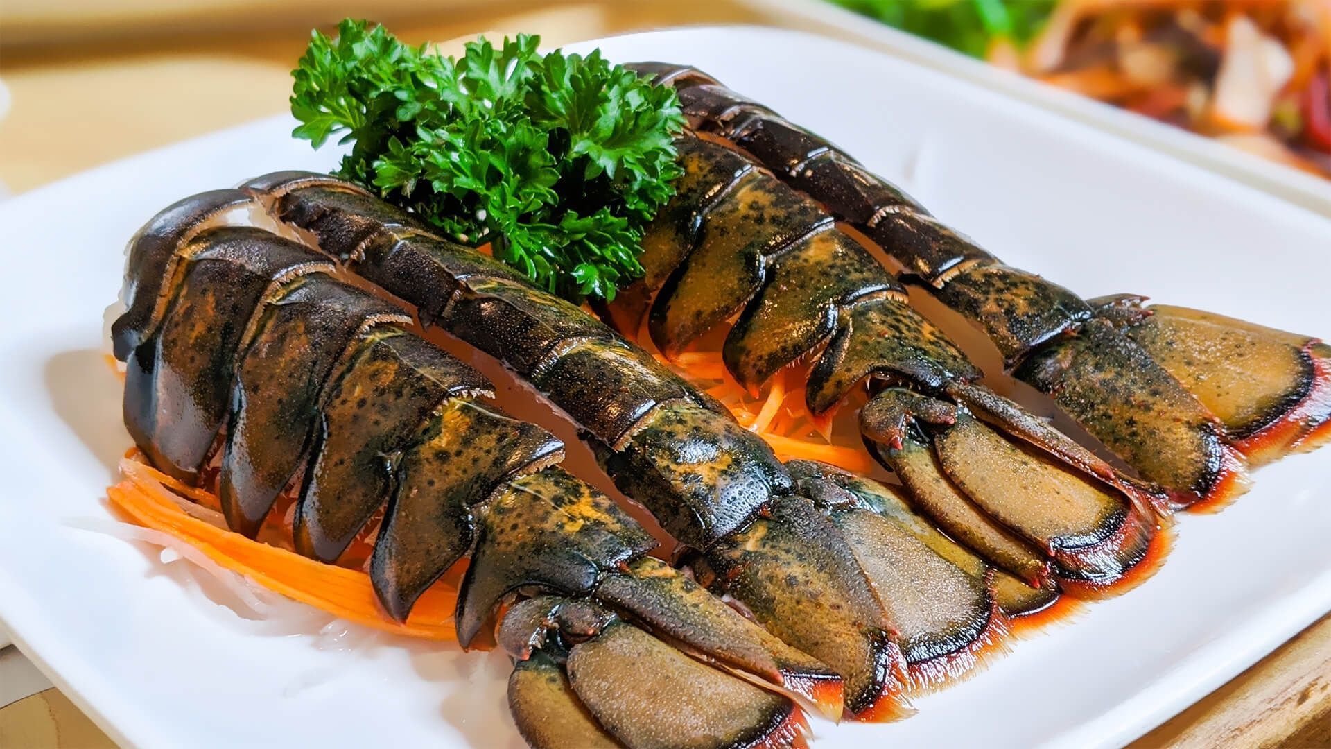 a white plate topped with sliced lobster tails and parsley