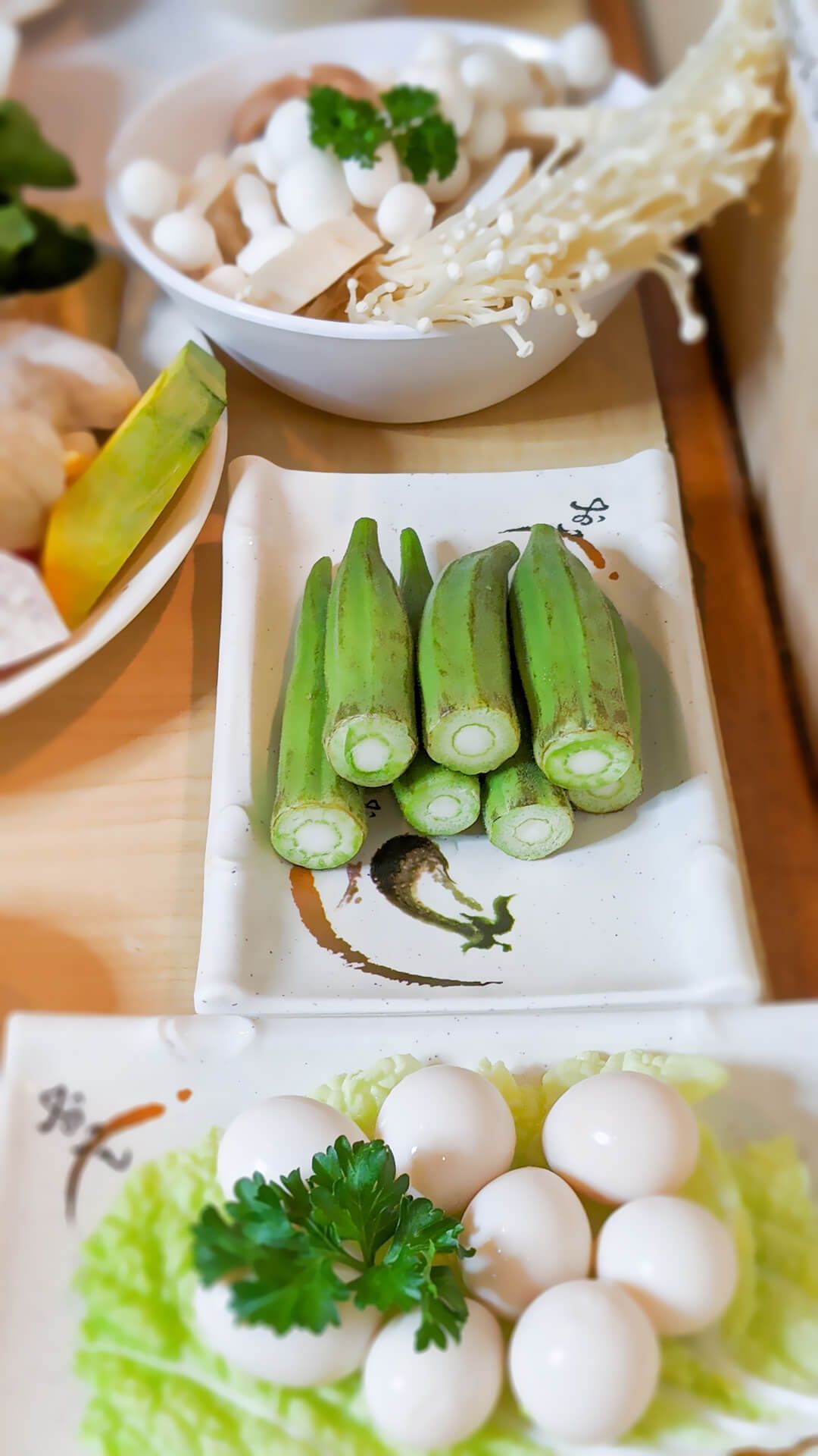 a table topped with plates of food including okra and eggs