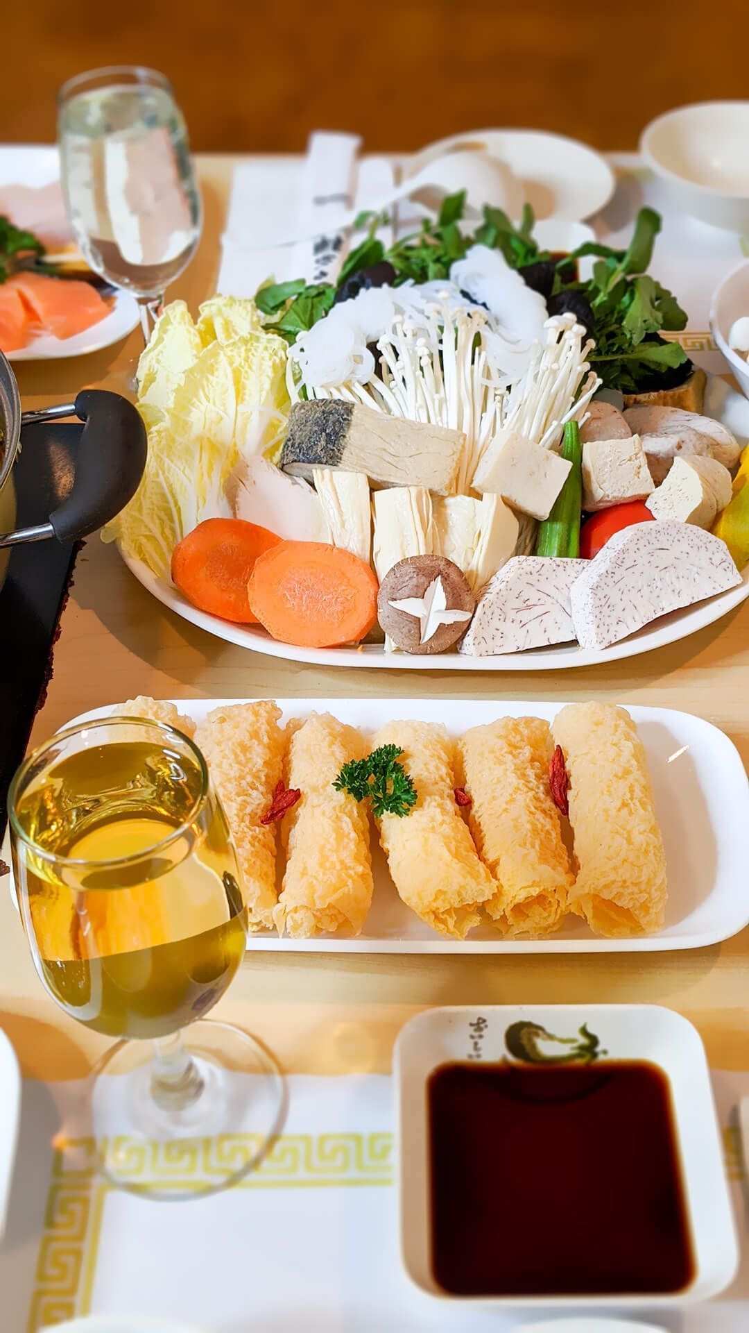 a table topped with plates of food and a glass of wine