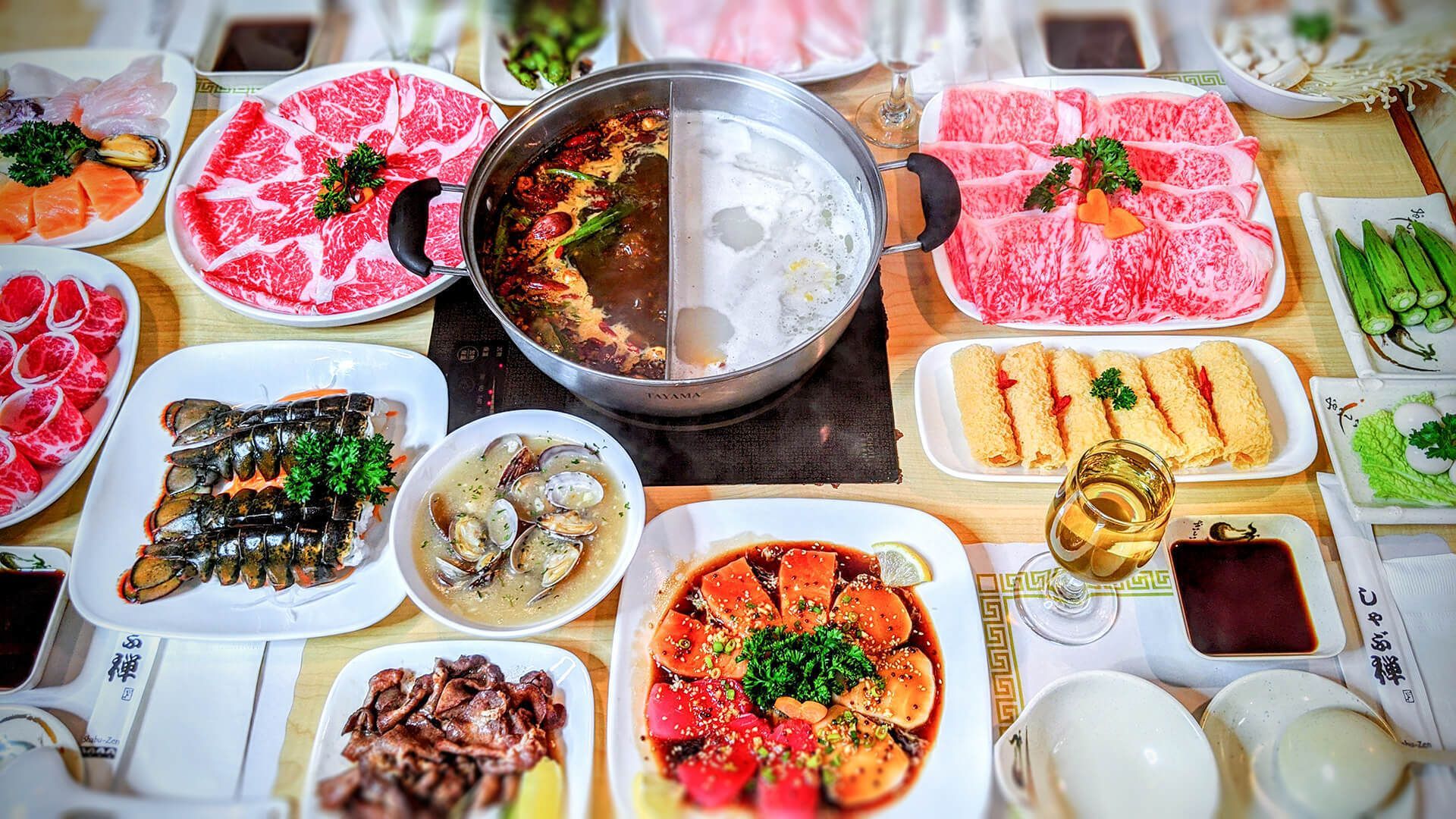 a table topped with plates of food and a pot of soup