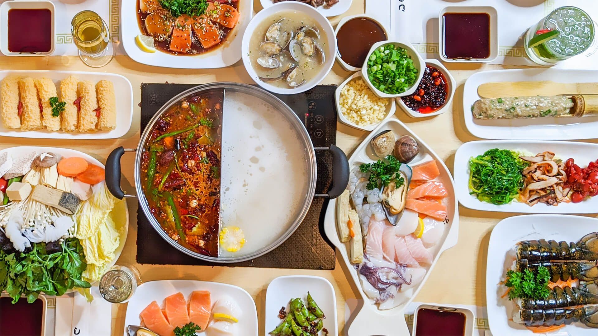 a table topped with plates of food and a pot of soup