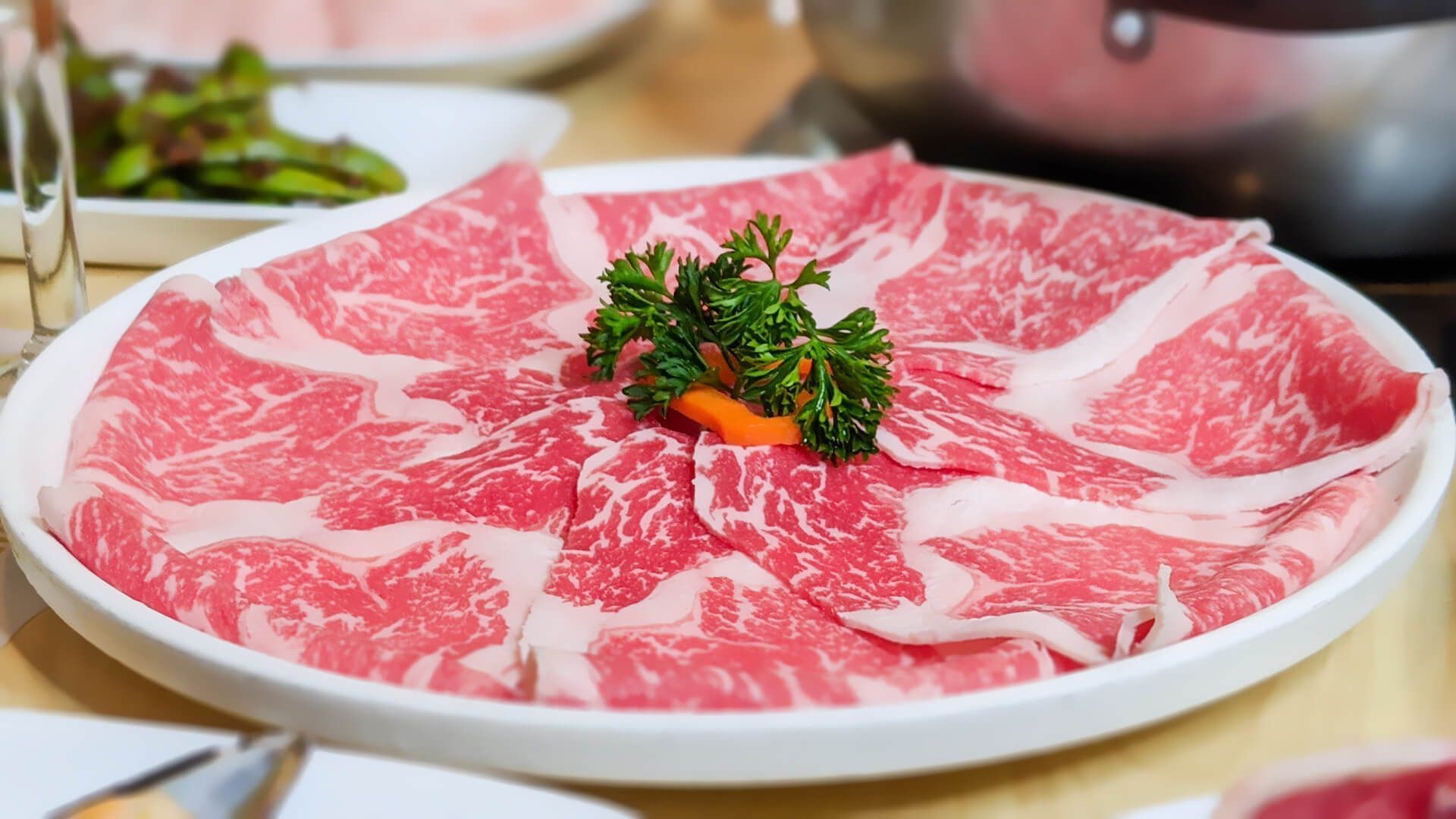 a white plate topped with sliced beef and parsley on a table