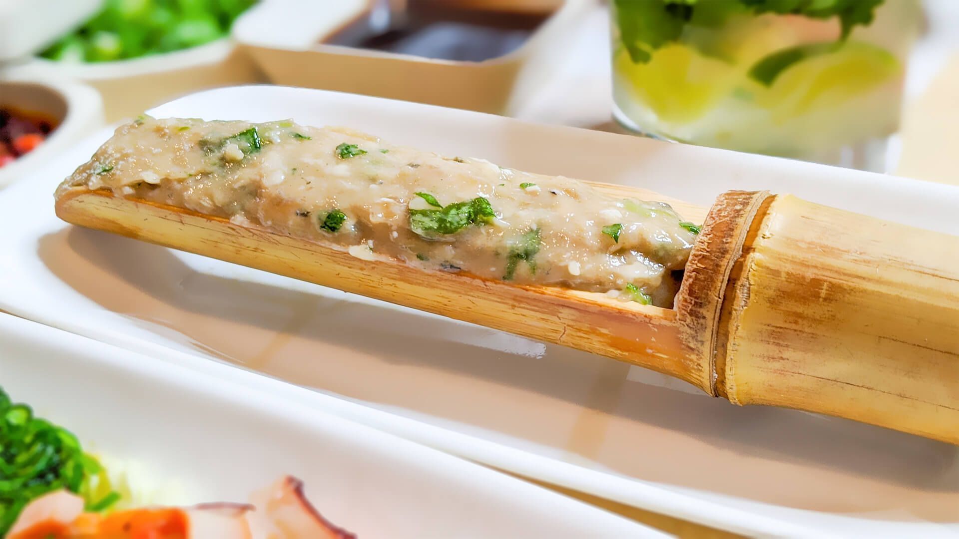 a close up of a bamboo stick filled with meat on a plate