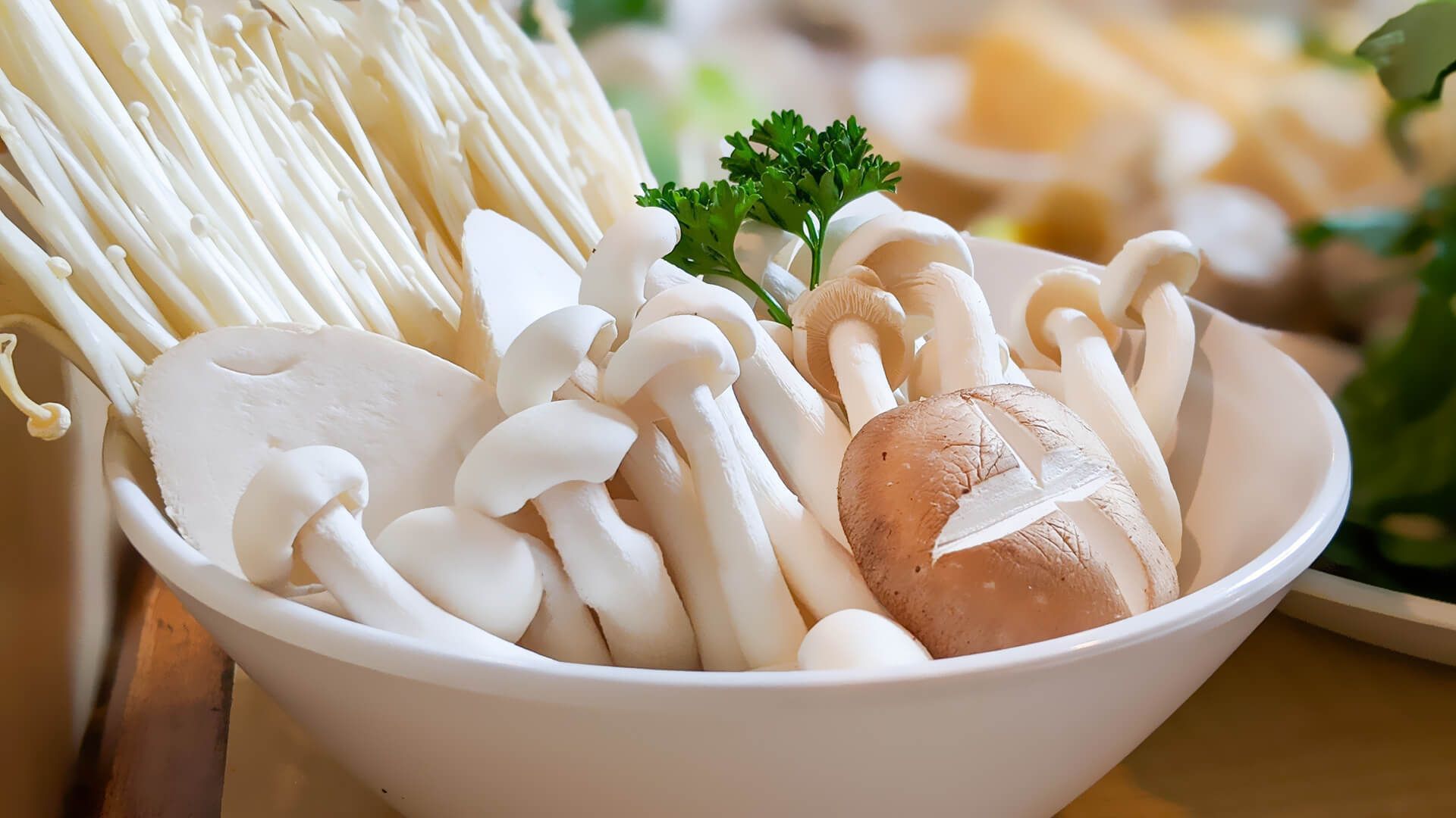 a bowl filled with different types of mushrooms on a table