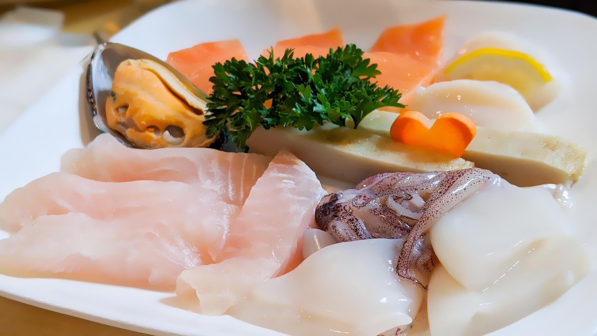 a white plate topped with a variety of seafood and vegetables