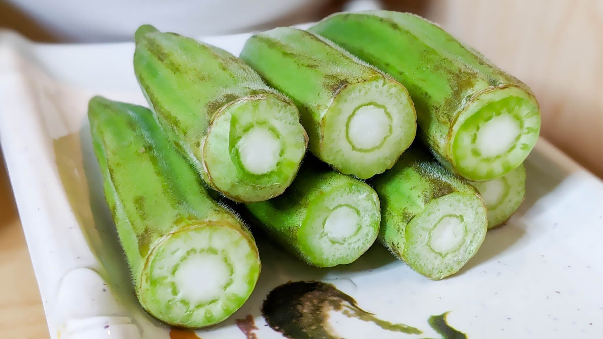 a bunch of green okra on a white plate