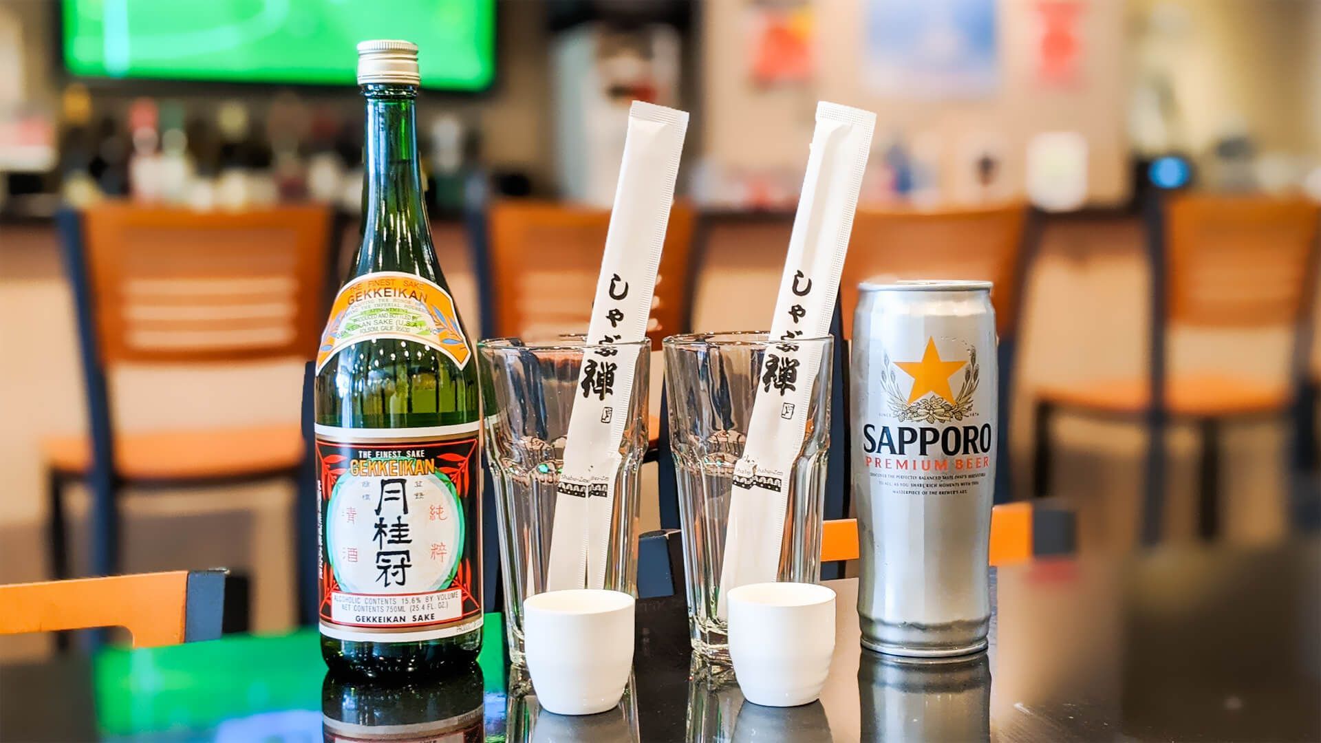 a bottle of beer and a can of beer are on a table in a restaurant
