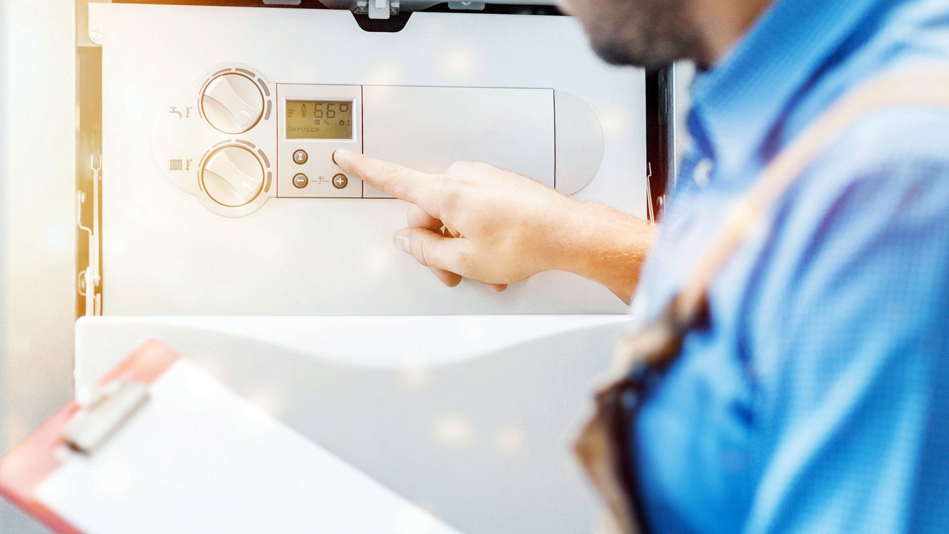 Person pressing controls on a wall-mounted thermostat in a bright room