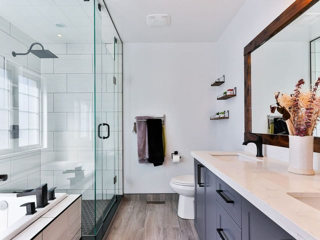 Modern bathroom with glass shower, floating vanity, and black-and-white decor