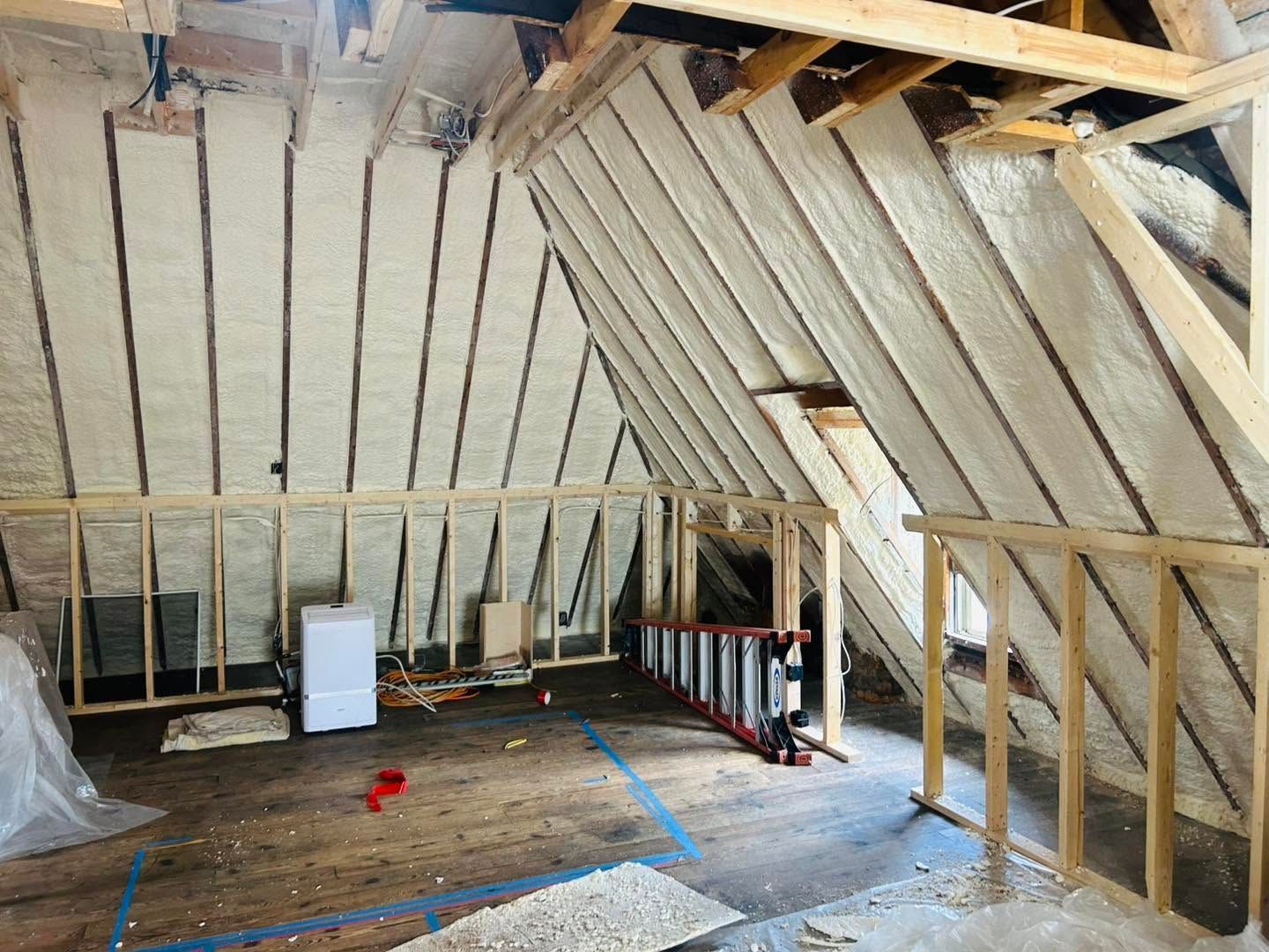 Unfinished attic interior with exposed wood framing, insulation, and a large open floor area under construction