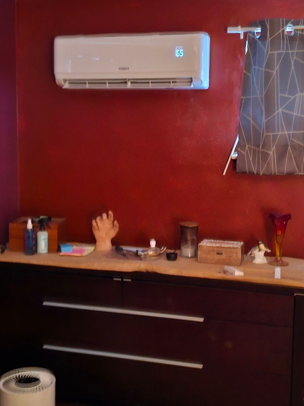 A red wall with a white air conditioner on it