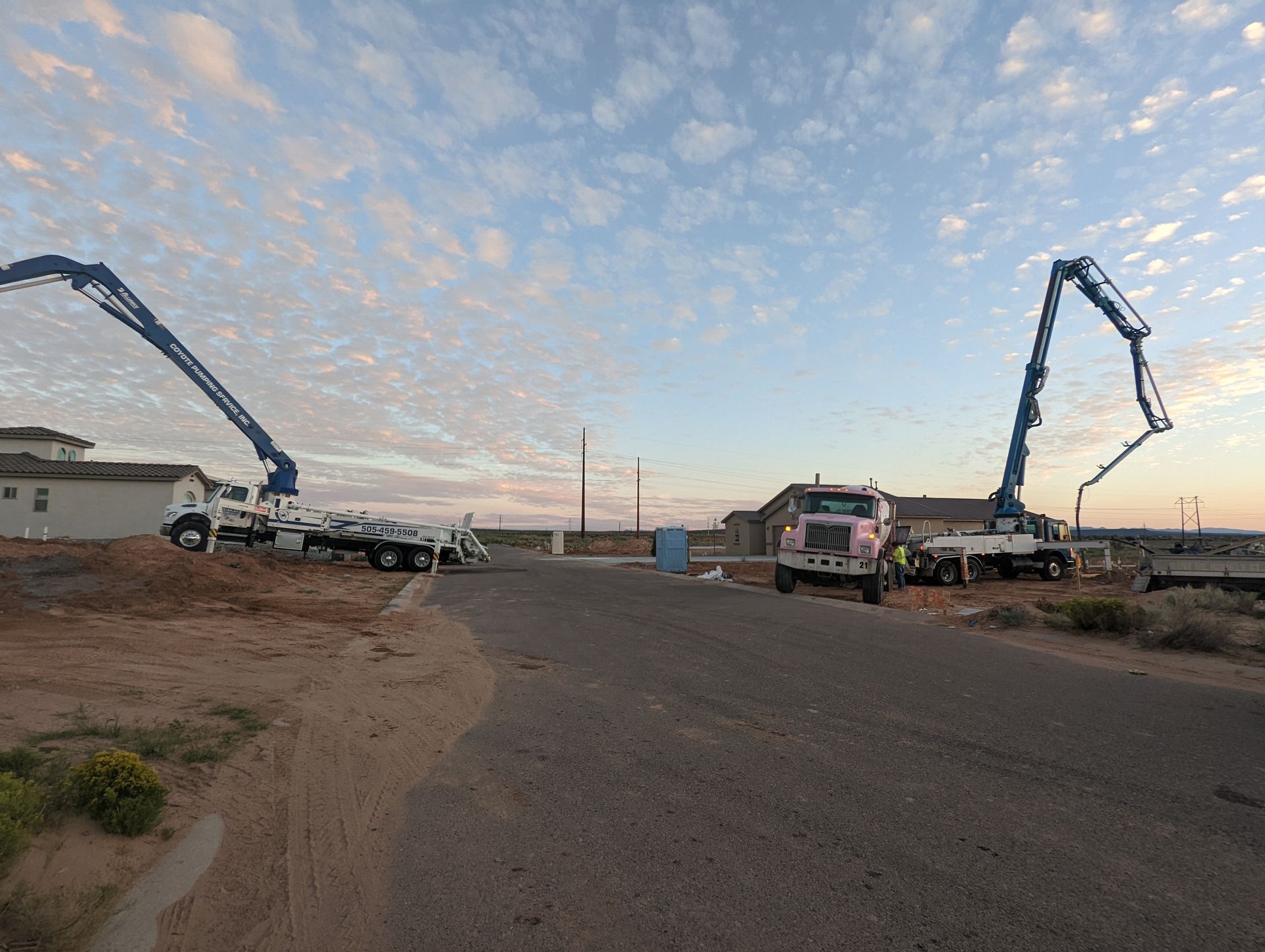 A couple of concrete pumps are sitting on the side of a road.