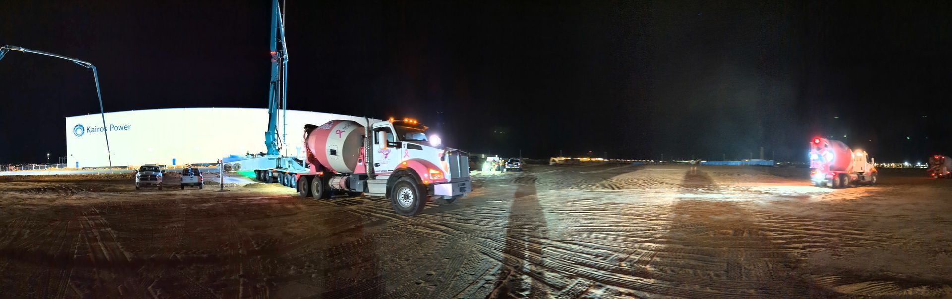 A truck is driving down a dirt road at night.