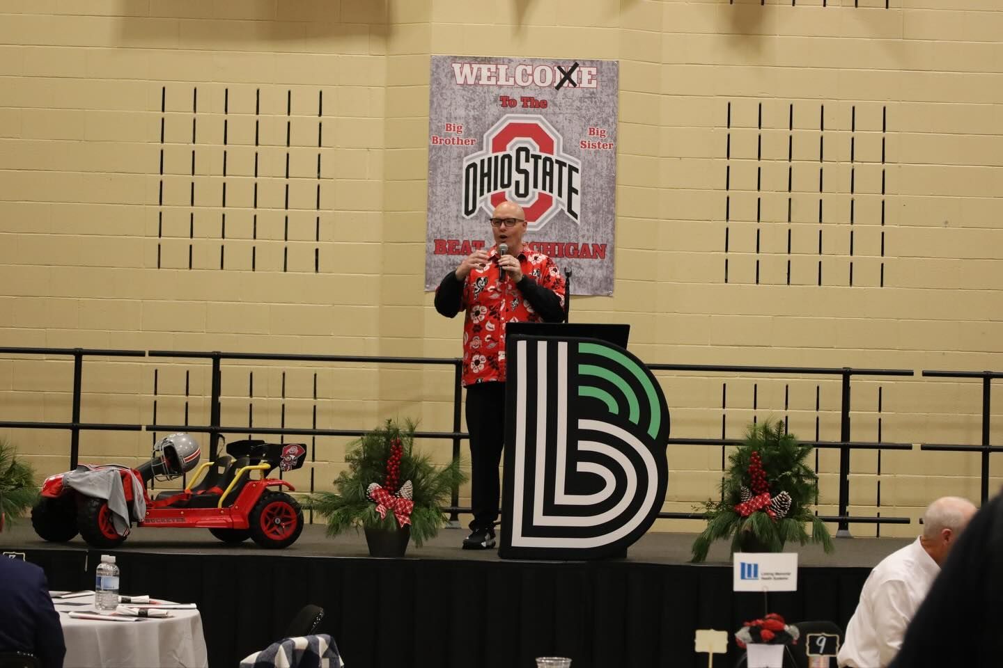Man speaking on stage at event.